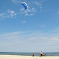 Chałupy - plaża człowiek menewrujący spadochronem zwanym też latawcem używanym do urpawiana KITESURFINGU czyli pływaniu na desce ze spadochornem bez żagla