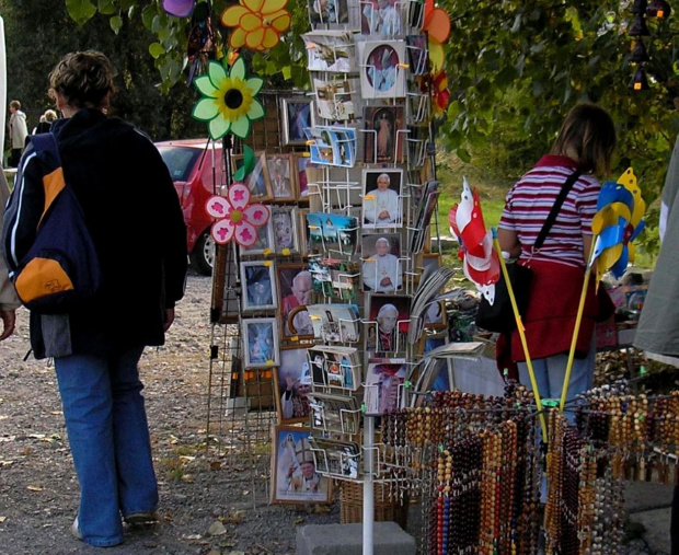 Łagiewniki. Stragany z dewocjonaliami, różańcami, portretami papieży, i zabawkami dla dzieci.